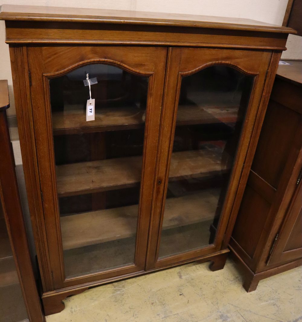 A late Victorian walnut two door glazed bookcase, width 102cm, depth 28cm, height 128cm